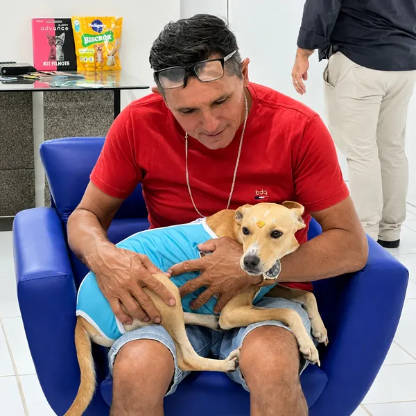 Tutor abraçando seu cão na recepção da Ame Mais